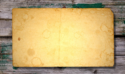 Old paper sheet on discolored wood. Useful for background.