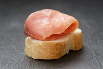 baguette slice with curred salmon on slate