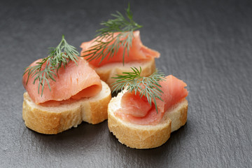 baguette slices with curred salmon on slate