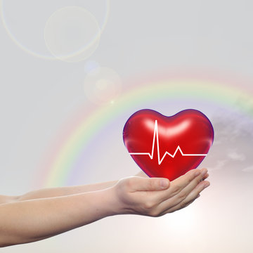 Human hand with heart and rainbow
