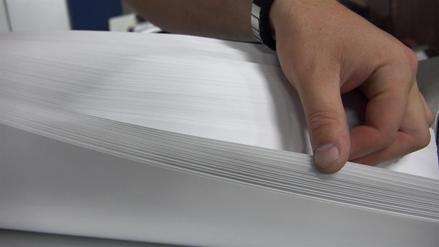 Worker Preparing Large White Papers for Print at the Printing Machine. UHD 4K stock footage