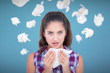 Composite image of portrait of sick woman sneezing in a tissue