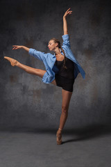 Young beautiful modern style dancer posing on a studio