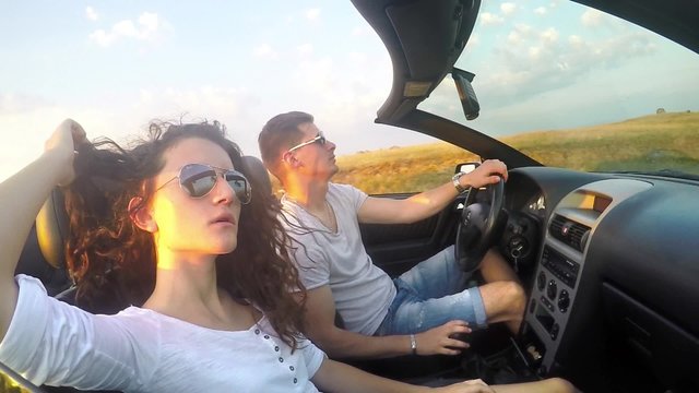 Young Caucasian couple fun driving luxury cabriolet convertable car. SLOW MOTION stock footage