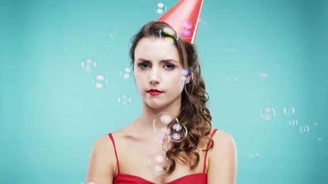 Single woman is sad in bubble shower slow motion photo booth blue background