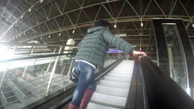 Happy woman on airport departure escalator. UHD 4K stock footage