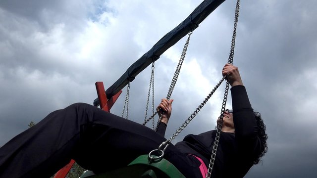 Young beautiful woman is having fun on a swing. Low angle view. UHD 4K  stock footage
