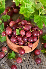 Red gooseberries in wooden bowl