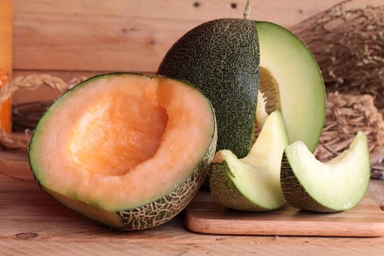 Cantaloupe melon fruit juicy on wood background.