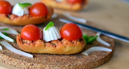Italian Bruschetta With Mozzarella And Tomato On A Wooden Table