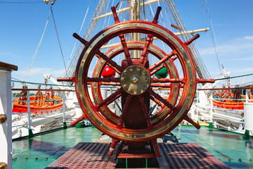 Wooden lacquer steering wheel of the sailboat.