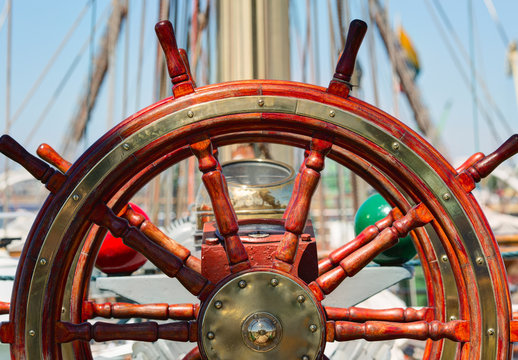 Wooden lacquer steering wheel of the sailboat.