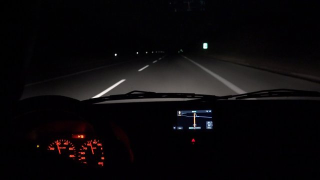 Car driving at night with illuminated dashboard and navigation, POV UHD 4K stock footage