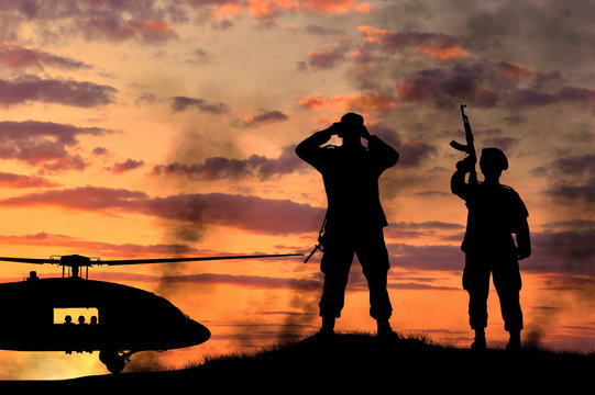 Silhouette of a soldiers and helicopter