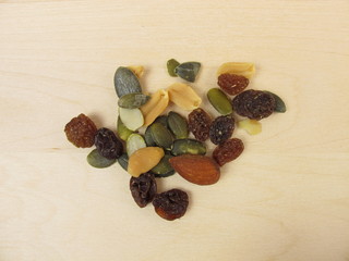 Nuts, seeds and raisins on wooden background
