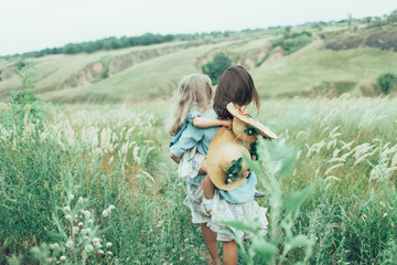 The young mother and daughter on green grass background 