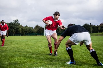 Fototapeta na wymiar Rugby players tackling during game