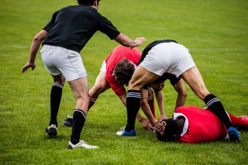 Rugby players tackling during game