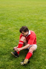 Rugby player tying his shoelace