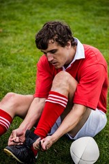 Rugby player tying his shoelace