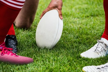 Rugby players in huddle with ball