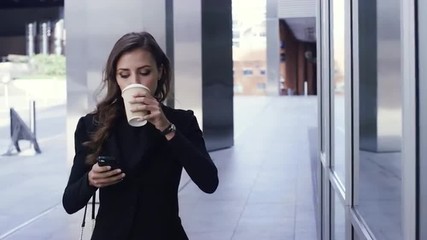 Attractive business woman commuter using smartphone walking in city of london - Powered by Adobe