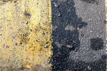 background asphalt dividing a yellow stripe closeup