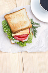 Sandwich and cup of black coffee on the table