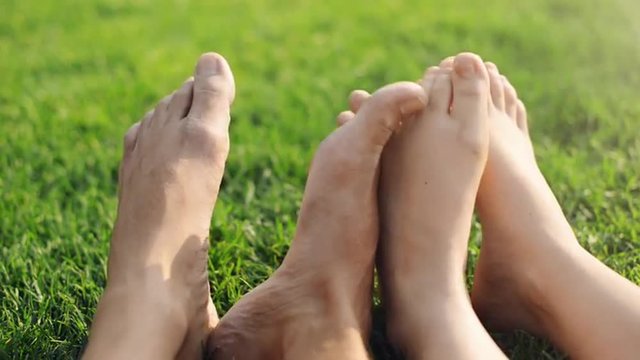 Barefoot feet of young couple in love playing footsie