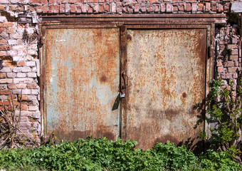 old rusty iron gate closed in a brick garage