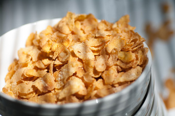 corn flakes poured from a plate stacked on the white table close