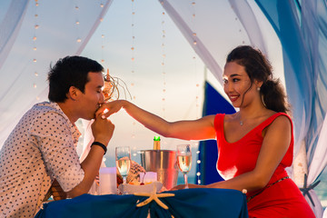 Young beautiful couple have a romantic dinner at sunset on a tro