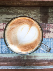 Heart latte art coffee on wooden background