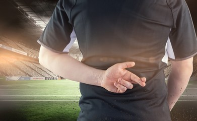 Composite image of back turned rugby player with fingers crossed
