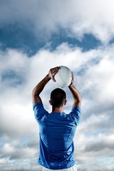 Composite image of rear view of rugby player throwing ball