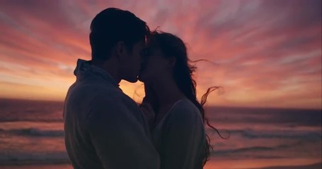 Happy couple kissing on beach at sunset silhouette in love dating on honeymoon RED DRAGON - Powered by Adobe