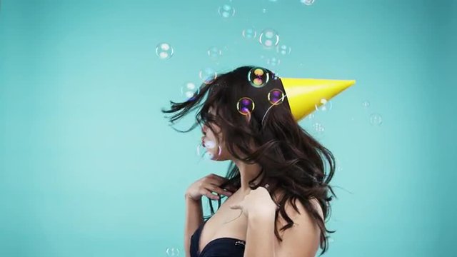 Crazy face busty Indian woman dancing in bubble shower slow motion photo booth blue background