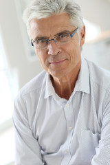 Fototapeta na wymiar Portrait of senior man with grey hair wearing eyeglasses