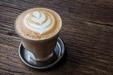 A cup of Latte art coffee on wooden table, copy pace