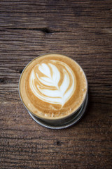 A cup of Latte art coffee on wooden table, copy pace