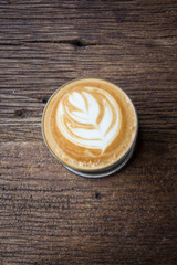 A cup of Latte art coffee on wooden table, copy pace