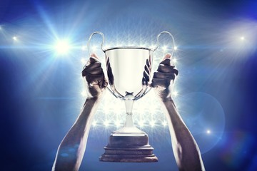 Composite image of cropped hand of athlete holding trophy - Powered by Adobe