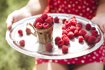 Woman holding a cup of raspberries