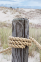 Thick rope bound to weathered wooden pole