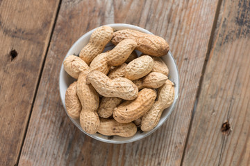 Peanuts in shells on wood background.