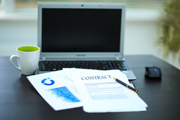 workplace with business diagrams, laptop, financial report in co