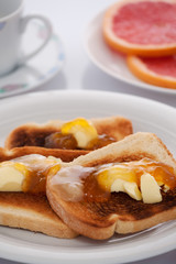 French toast and sliced orange on white tablecloth