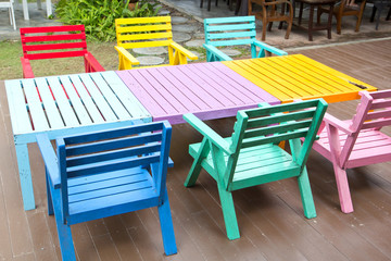 Colorful wooden armchairs beside a river