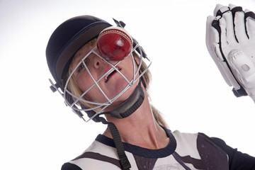 Cricketer wearing safety helmet being hit by a cricket ball