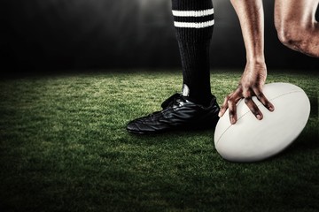 Composite image of low section of athlete holding ball  - Powered by Adobe